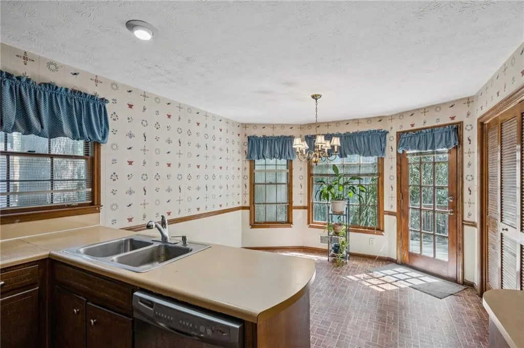 Sunny eat-in kitchen space with door out the deck. Bifold laundry doors on right.