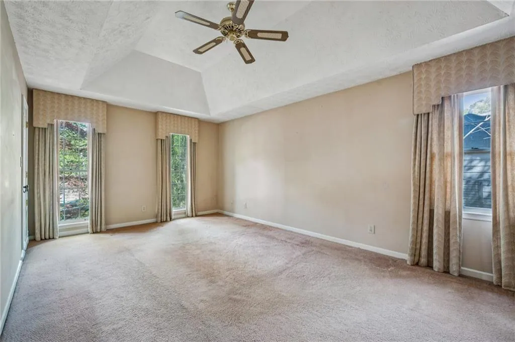 Large primary bedroom with three good-sized closets and vaulted ceiling. Professional window treatments.