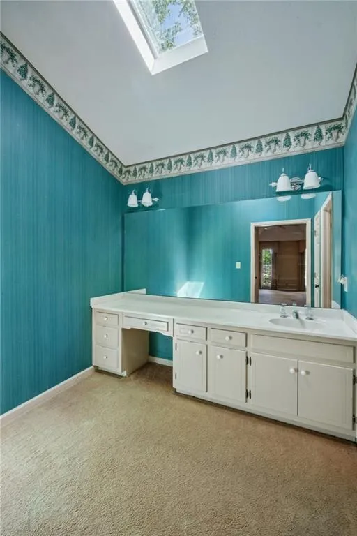 Tons of space in this primary bath to make what you want! Vaulted ceiling with skylight.