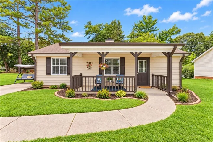 Covered front porch with dark wood railing and support beams