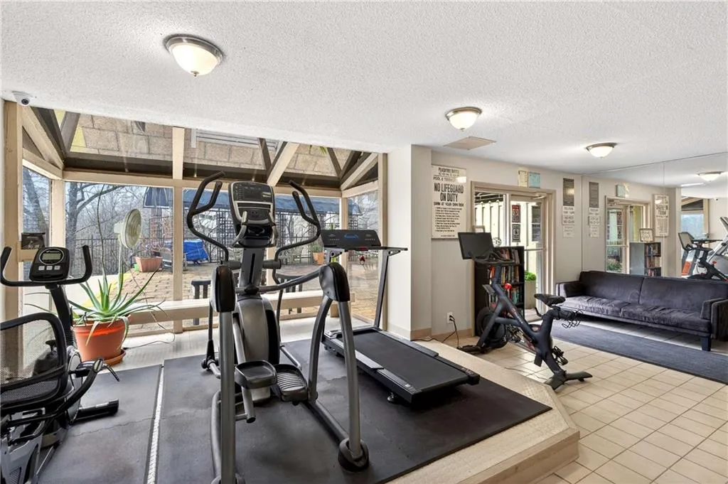 Workout room with a textured ceiling and a wall of windows
