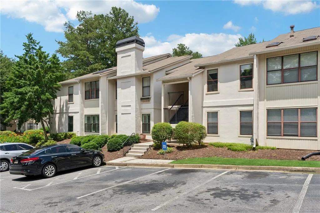 View of building exterior featuring uncovered parking