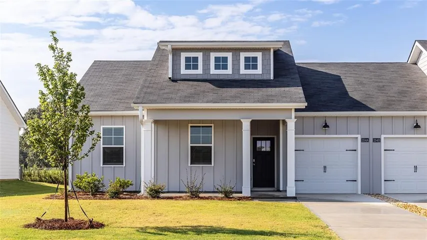 Contemporary exterior with board and batten siding, multiple garages, and a prominent dormer