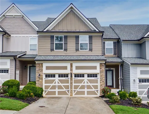 Contemporary townhome with a two-car garage, stone accents, and a covered entry