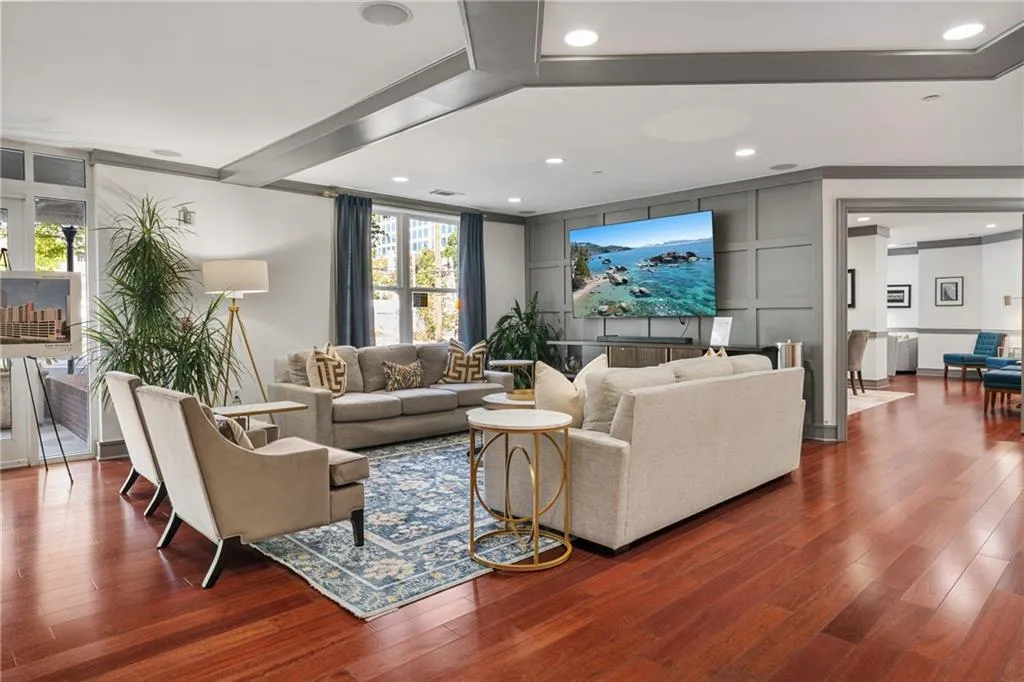 Living area with hardwood / wood-style floors, recessed lighting, and a decorative wall