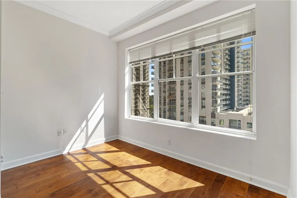 Spare room featuring plenty of natural light, ornamental molding, and dark wood finished floors