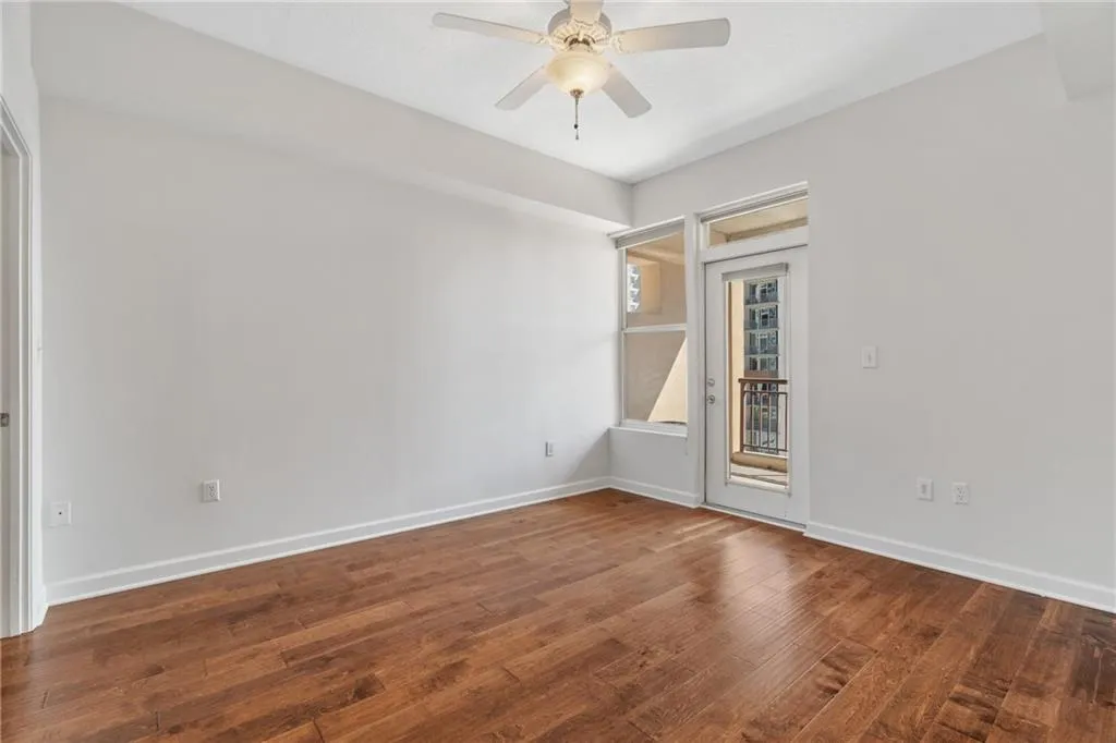 Unfurnished room with dark wood-style floors and a ceiling fan