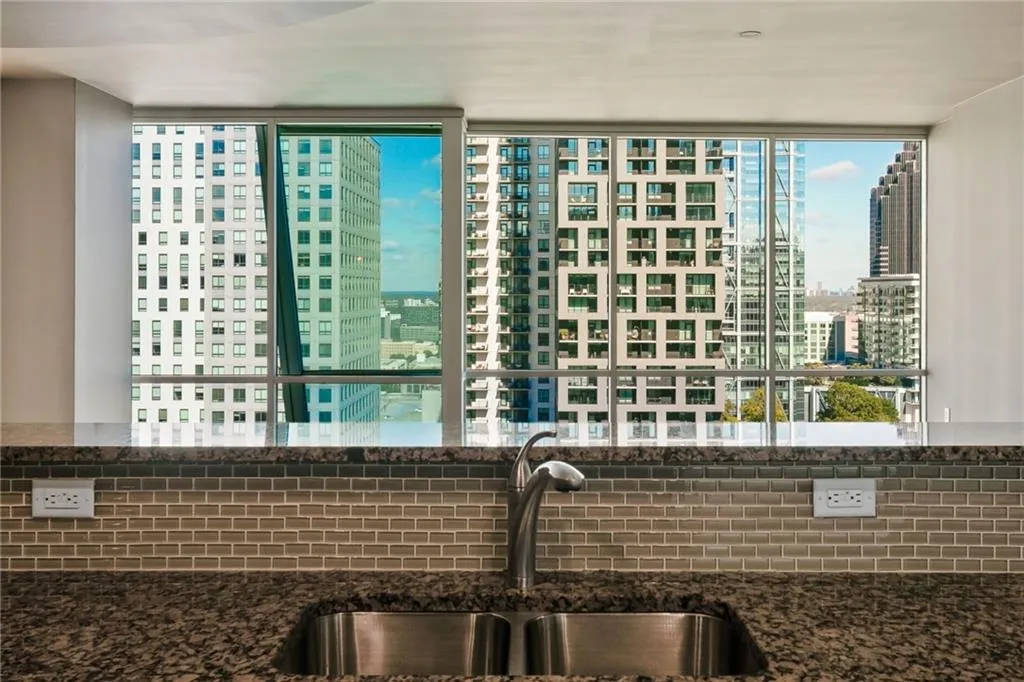 Kitchen featuring a view of city, dark stone counters, and tasteful backsplash