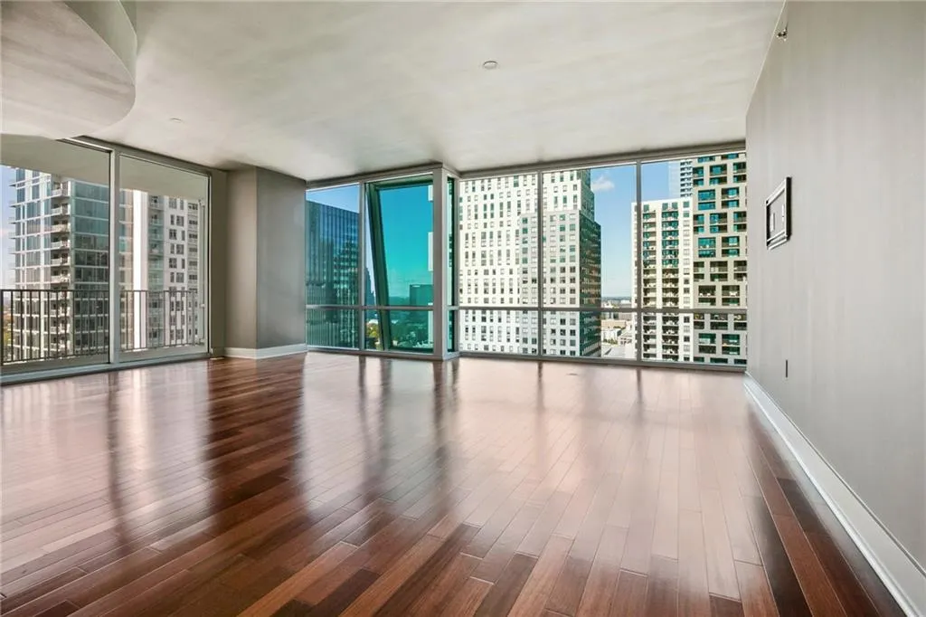 Living room featuring a view of city, a wall of windows, and wood finished floors