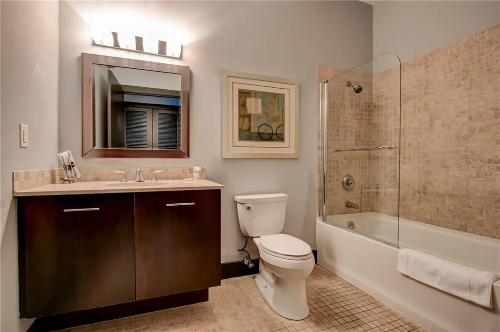 Guest Suite Full bath with shower / bathtub combination, vanity, and light tile patterned flooring