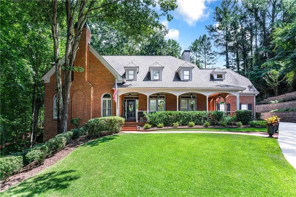 Brick beauty with flat front lawn and covered porch