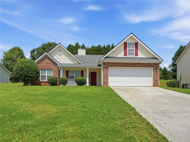 Brick and siding exterior with a covered entry, attached two-car garage, and concrete driveway