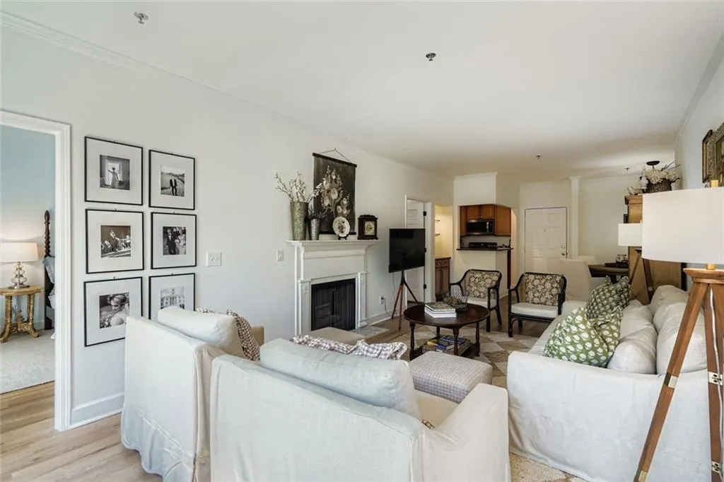 Living area with a fireplace, light wood-type flooring, and ornamental molding