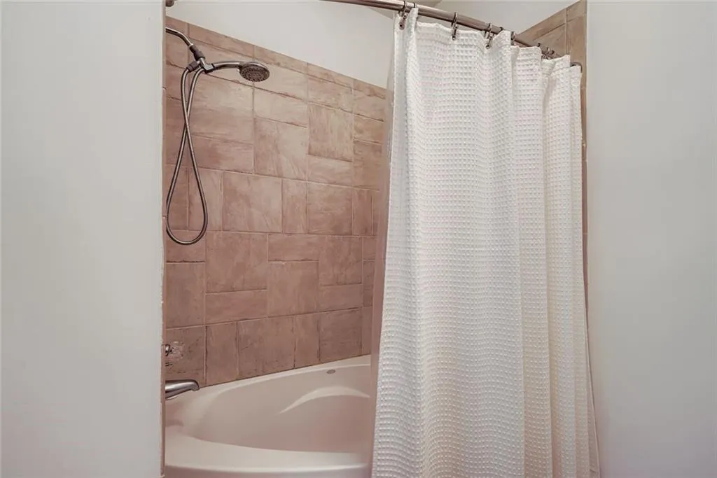 Full bathroom with shower / bath combination with curtain