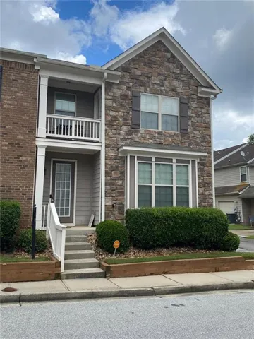 Stone and siding exterior featuring a second-story balcony