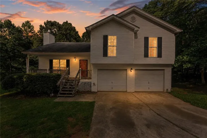 Two-story residence with a covered front porch, white siding, and a two-car garage