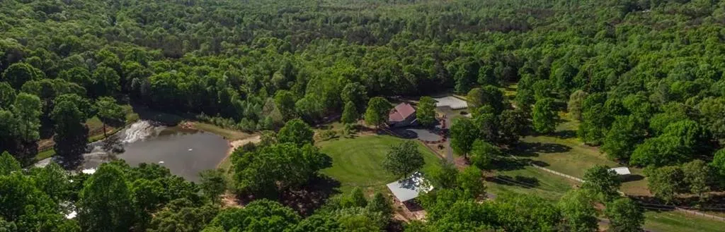 Bird's eye view of the pond, 3-car garage, Barn, & wooded area
