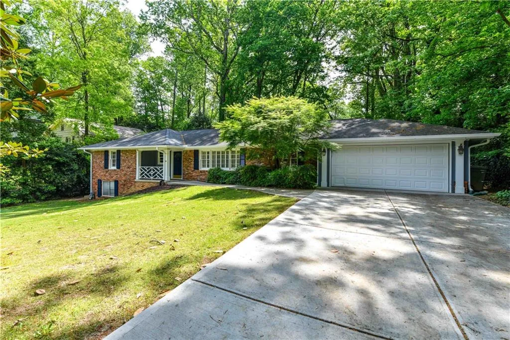 Single story home featuring brick siding, a front yard, and concrete driveway