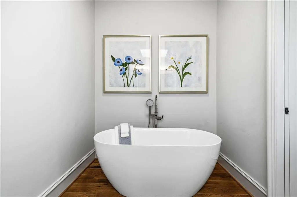 Freestanding soaking tub featuring a floor-mounted faucet with handheld spray