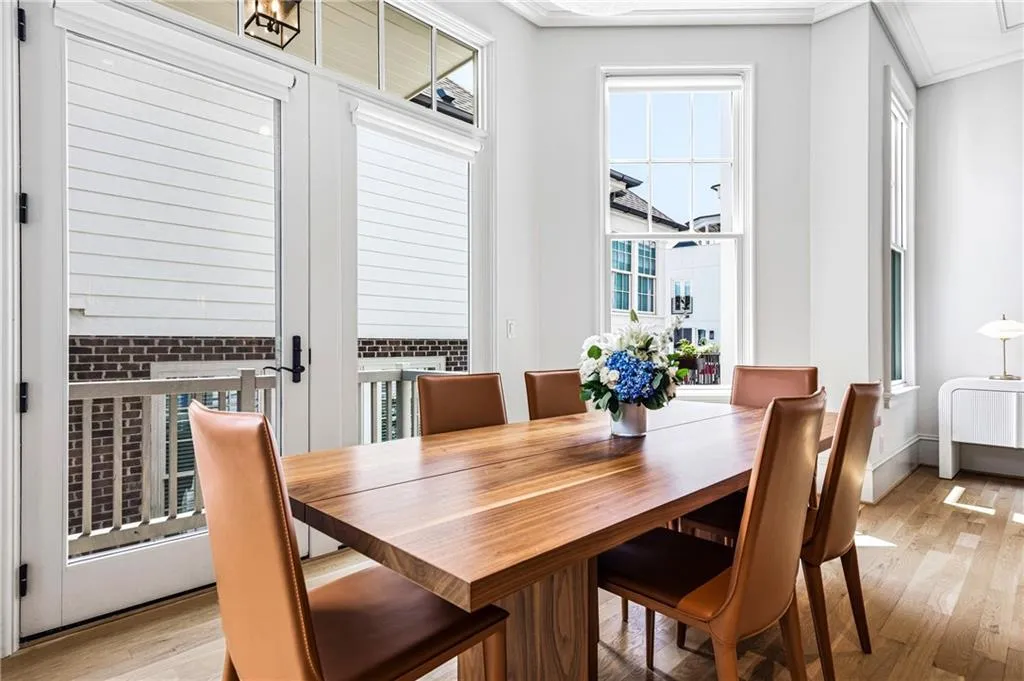 Dining area featuring wood-finish flooring, white walls, and a large multi-pane window