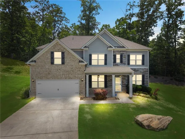 Two-story colonial featuring a brick and siding exterior, two-car garage, front-load architectural shingles, and multiple windows with black shutters