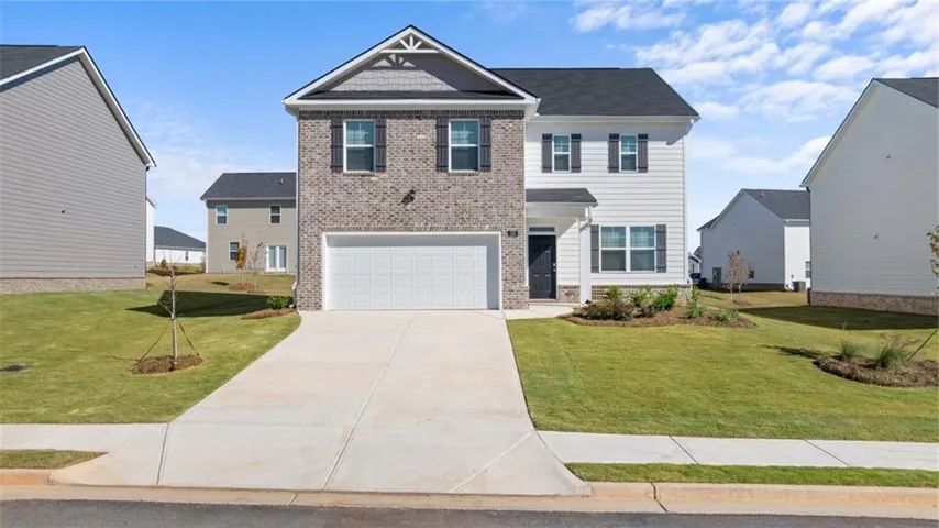 Craftsman-style home featuring driveway, a front lawn, and a garage