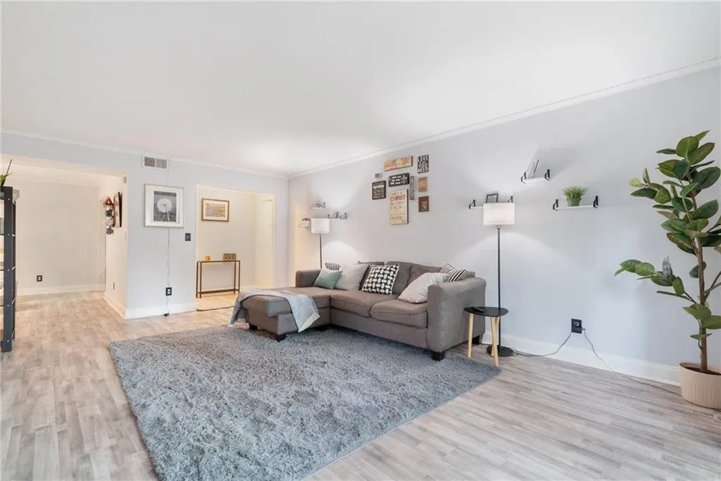 Living room with crown molding and light hardwood / wood-style flooring