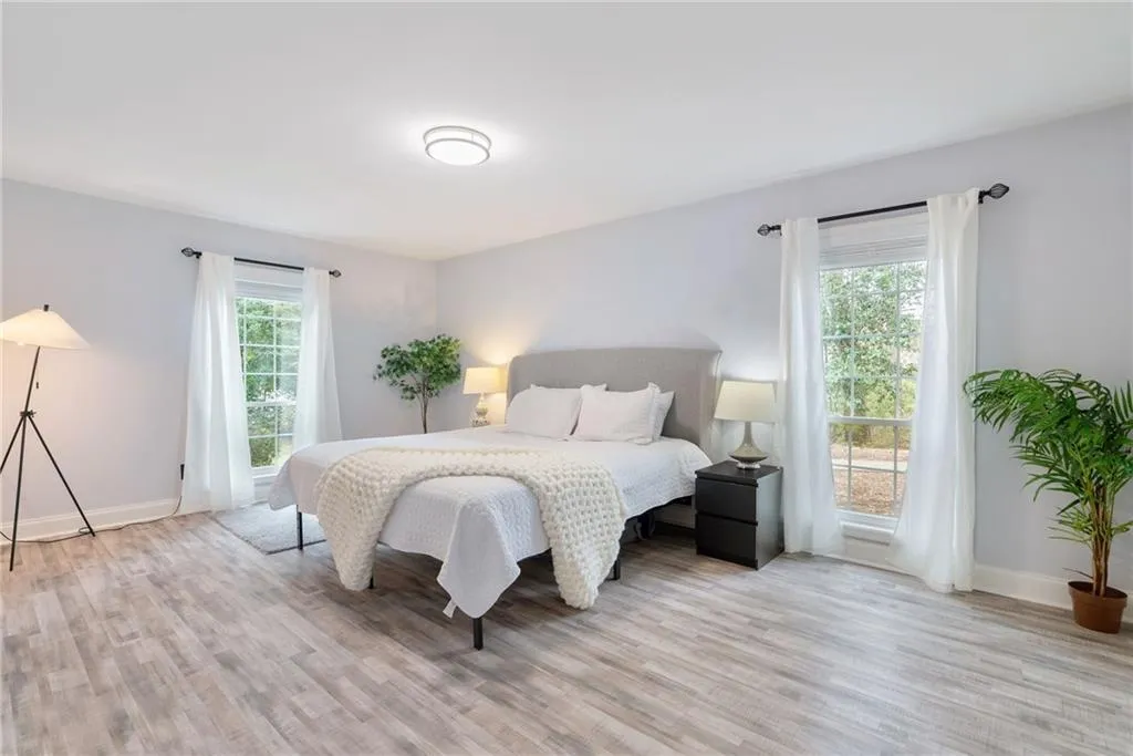 Bedroom with multiple windows and light wood-type flooring