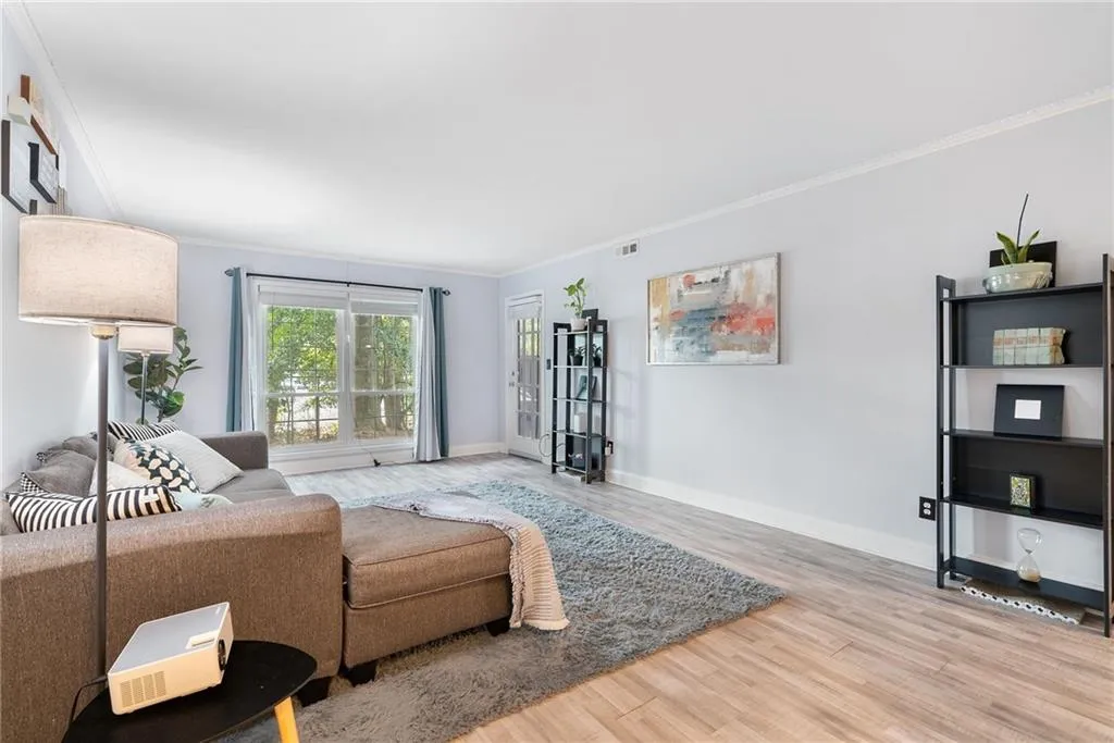 Living room with hardwood / wood-style floors and crown molding
