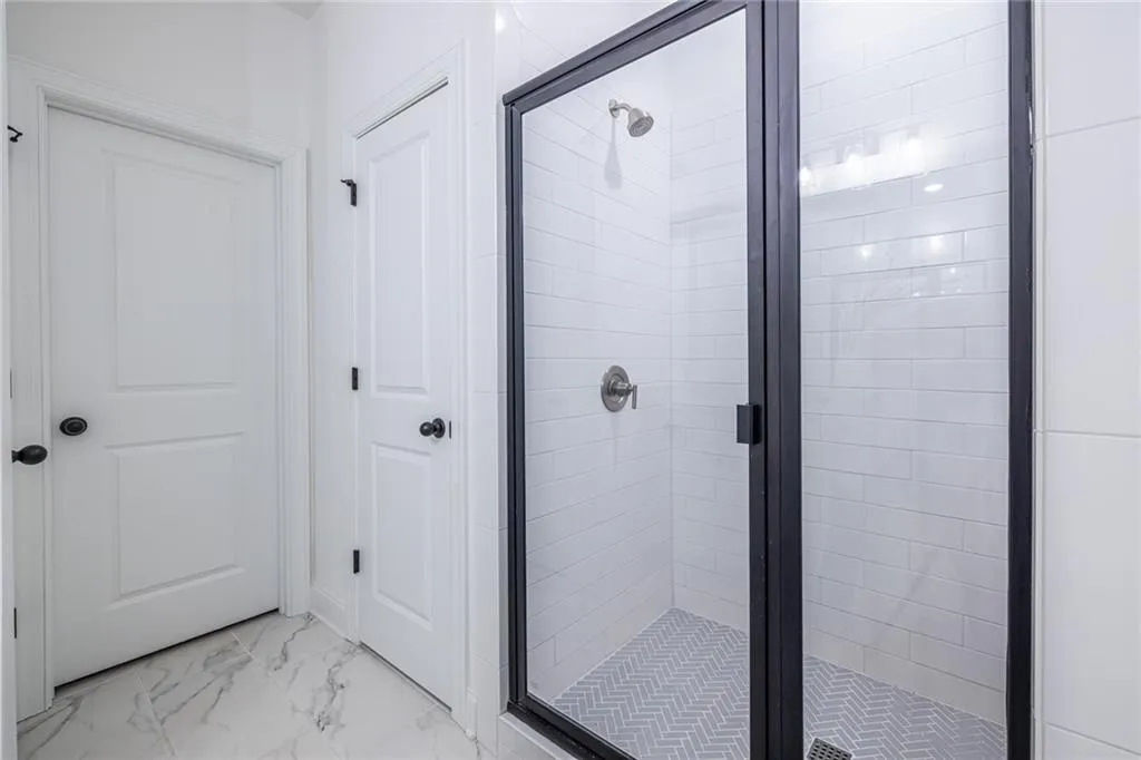 Full bathroom with a stall shower and marble look tiles