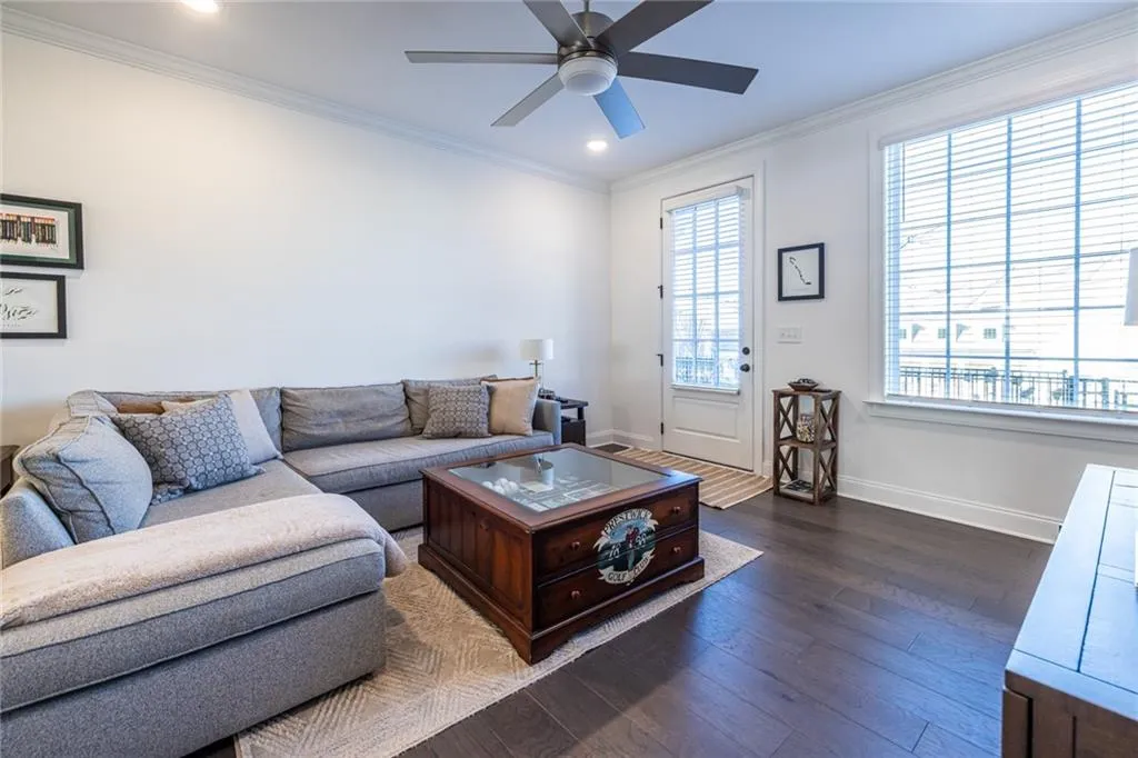 Living area featuring a ceiling fan, dark wood-style floors, ornamental molding, and recessed lighting