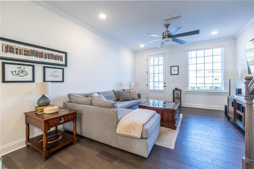 Living area with dark wood-style flooring, ornamental molding, a ceiling fan, and recessed lighting