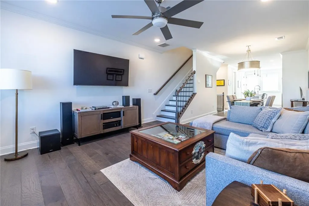 Living area featuring ornamental molding, stairway, ceiling fan, dark wood finished floors, and recessed lighting