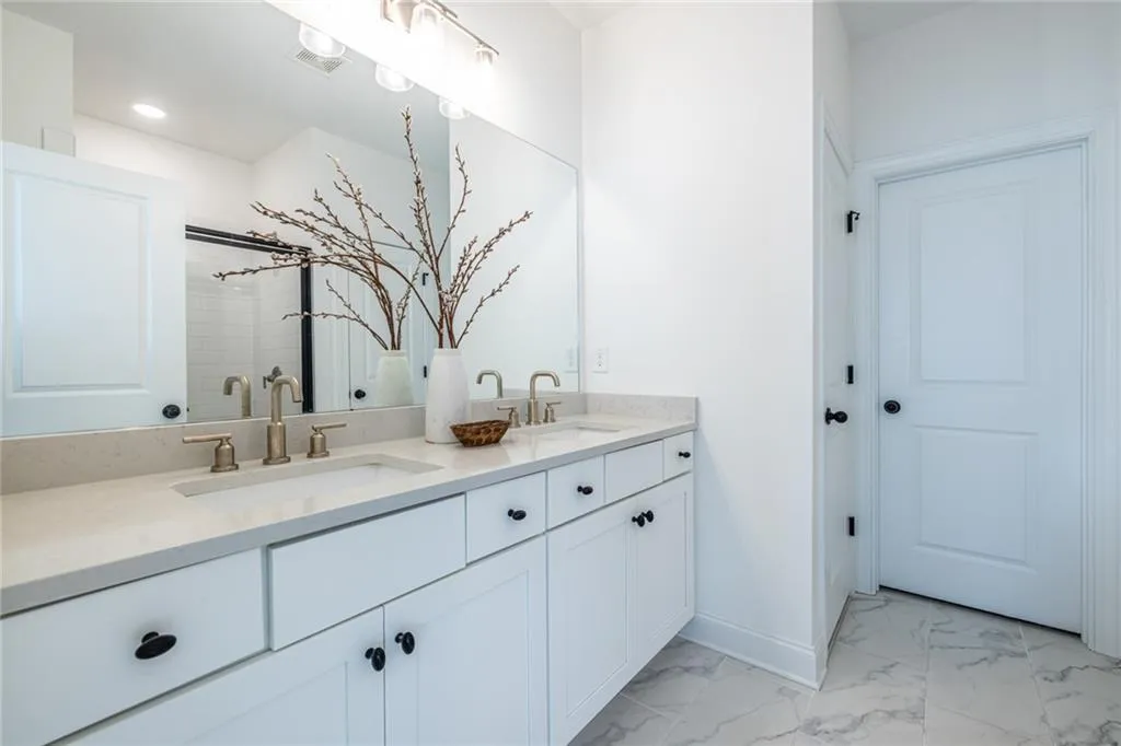 Full bathroom featuring double vanity, marble finish floors, and recessed lighting