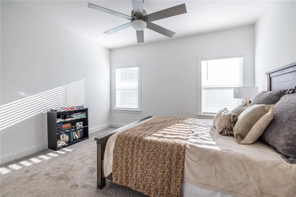 Carpeted bedroom featuring baseboards and ceiling fan