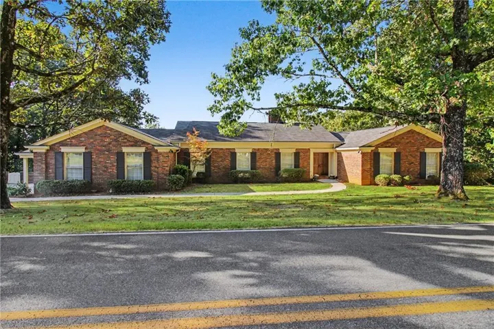 Brick exterior with dark shutters, gabled rooflines, and a covered front entry