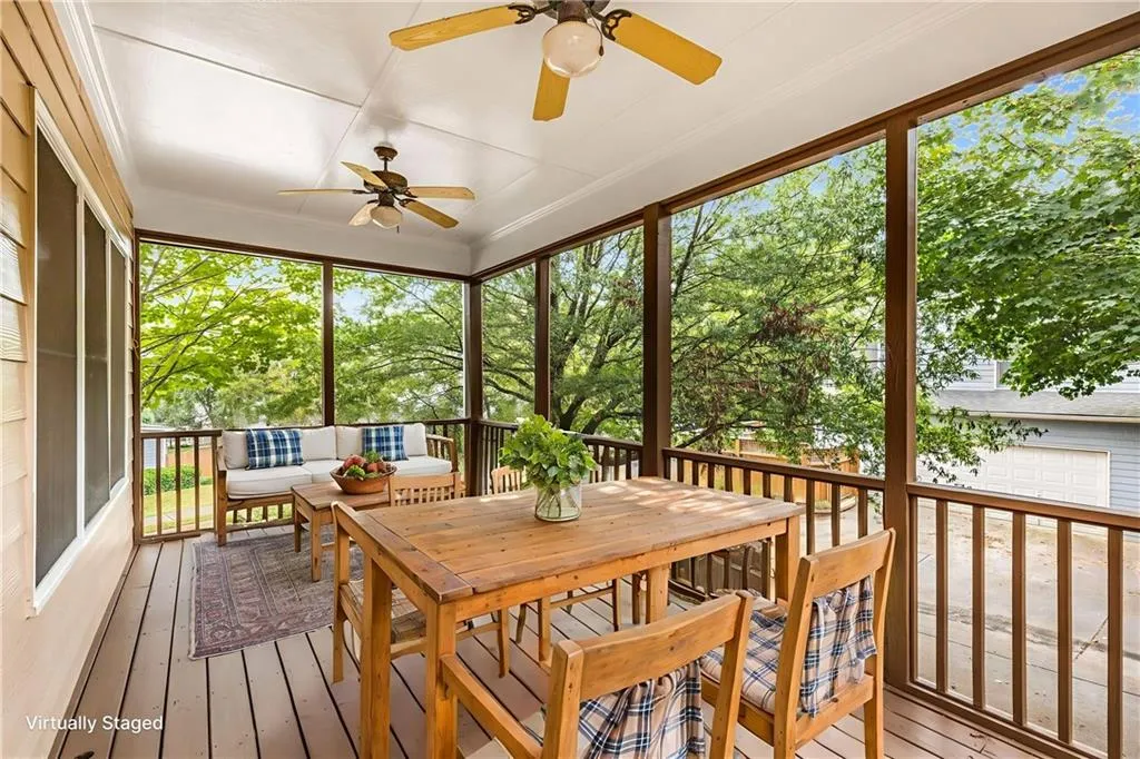 Sunroom with healthy amount of natural light, a wooden deck, outdoor dining space, and ceiling fan