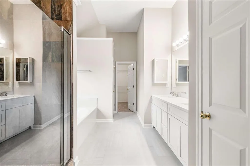 Full bath with vanity, a shower stall, and a garden tub