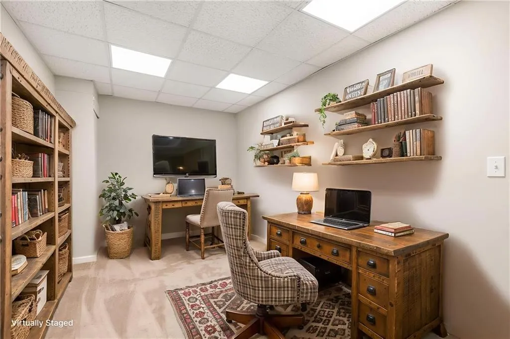 Office space with light carpet and a drop ceiling