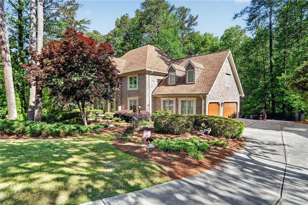View of front of home featuring brick siding and a shingled roof