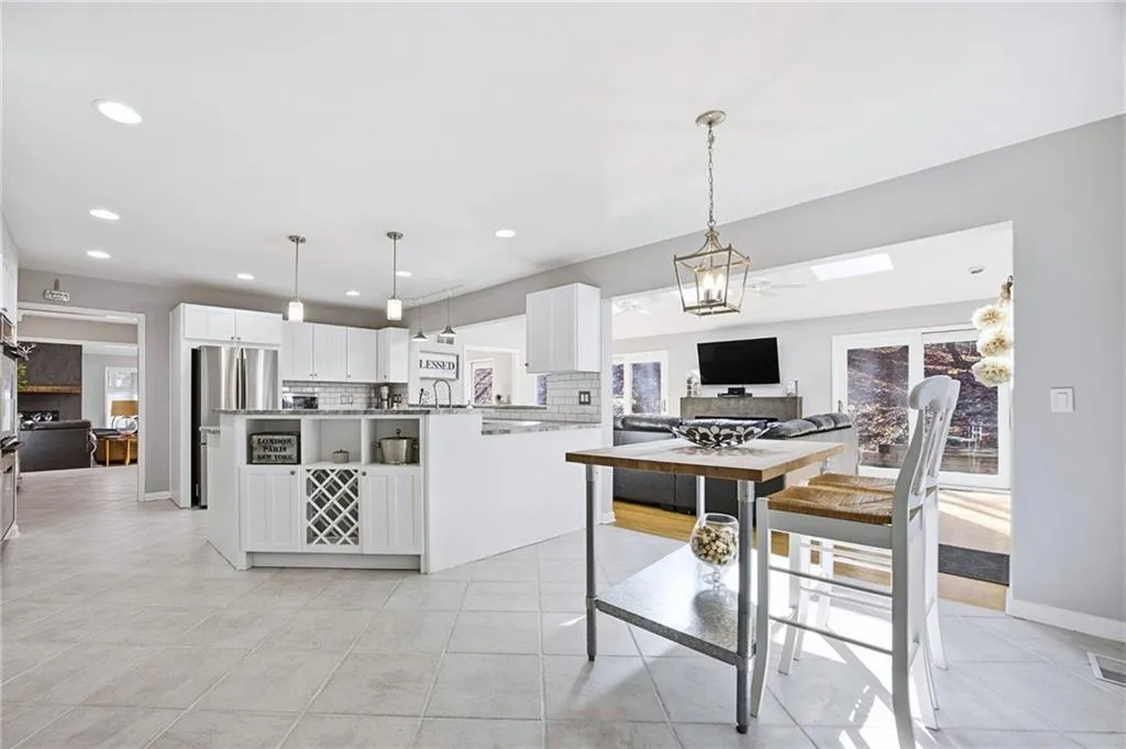 Bright eat-in kitchen with modern lighting and seamless flow to dining and living spaces
