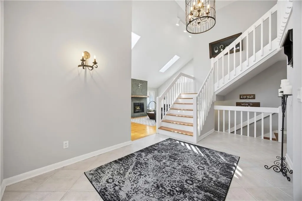 Front foyer with vaulted ceilings, chandelier, and open staircase