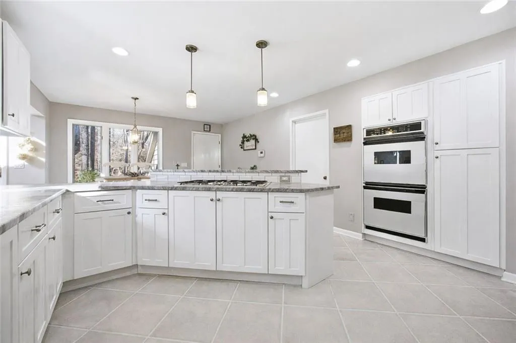 Chef’s kitchen featuring gas cooktop, double ovens, and abundant cabinet storage