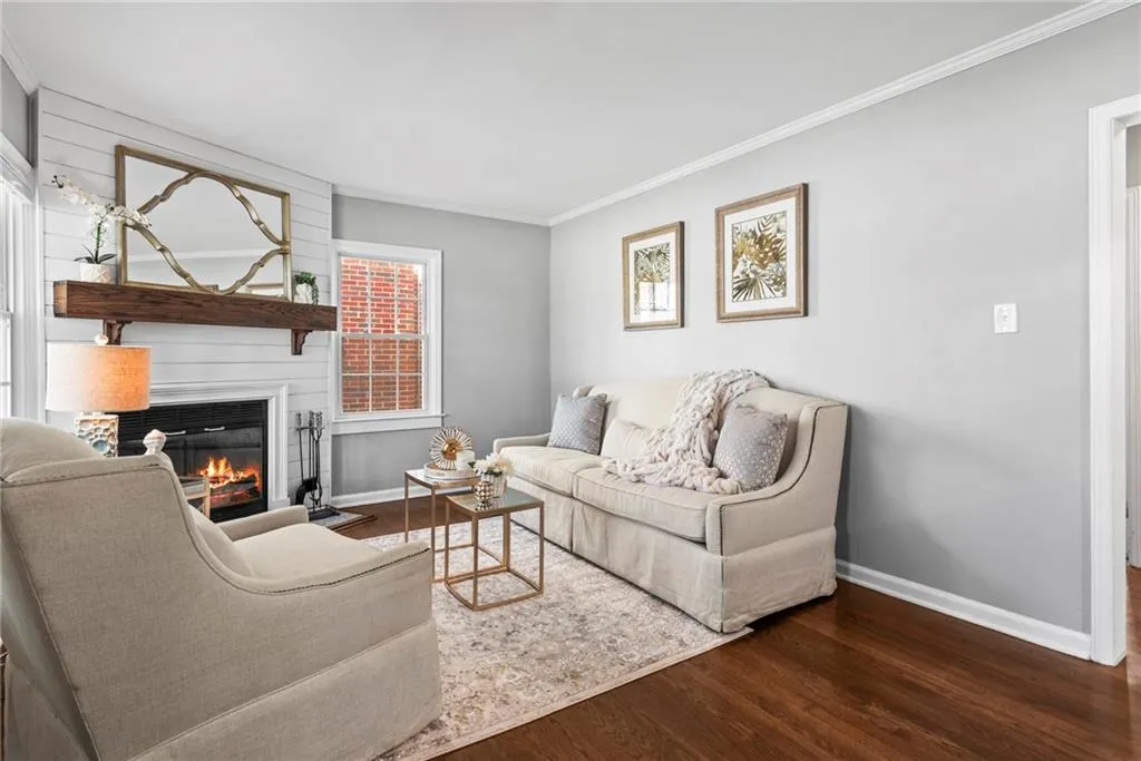 Living room has wood-burning fireplace and hardwood floors.