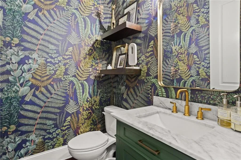 Half Bath on the first floor offers an upgraded vanity for optimal storage, complimented by upgraded fixtures, lighting and mirror