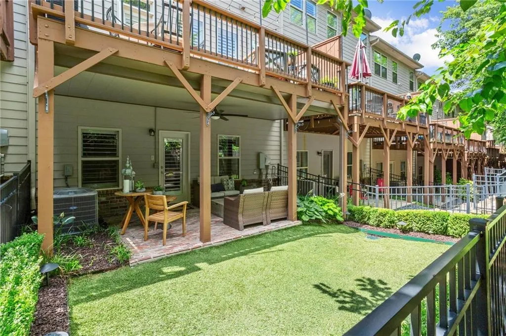 This fenced backyard offers additional landscaping with shrubbery installed along perimeter of the astroturf greenspace