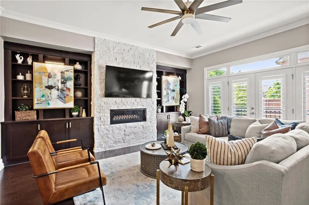 Living room features stained custom builtins which flank the upgraded custom modern fireball gas fireplace insert accentuated by a floor to ceiling stacked stone accent wall