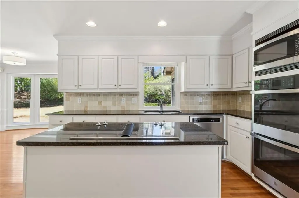 Great shot of kitchen sink view to the outdoors and new double ovens and microwave