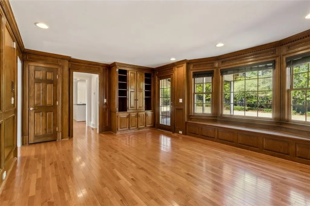 View into the kitchen, shows off the judge's paneling and more cabinetry with hidden Wetbar, and bench seating overlooking the backyard