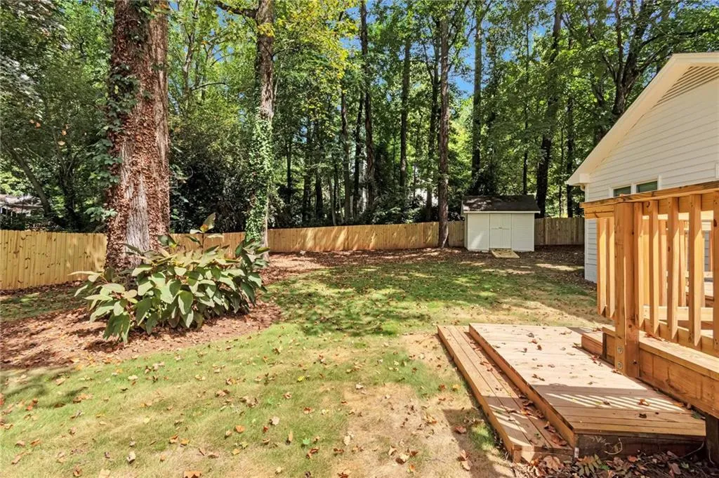 View of yard with a wooden deck and a storage shed